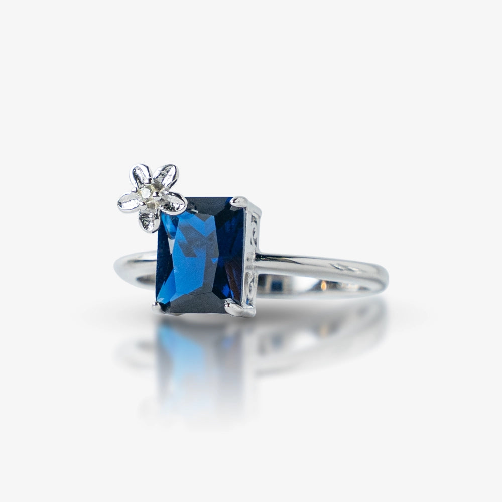 Elegant and unique, this Sterling Silver 925 Blue Sapphire Flower Ring features a stunning rectangular blue stone accented with a delicate flower detail for a feminine touch. Its timeless design makes it a perfect statement piece.