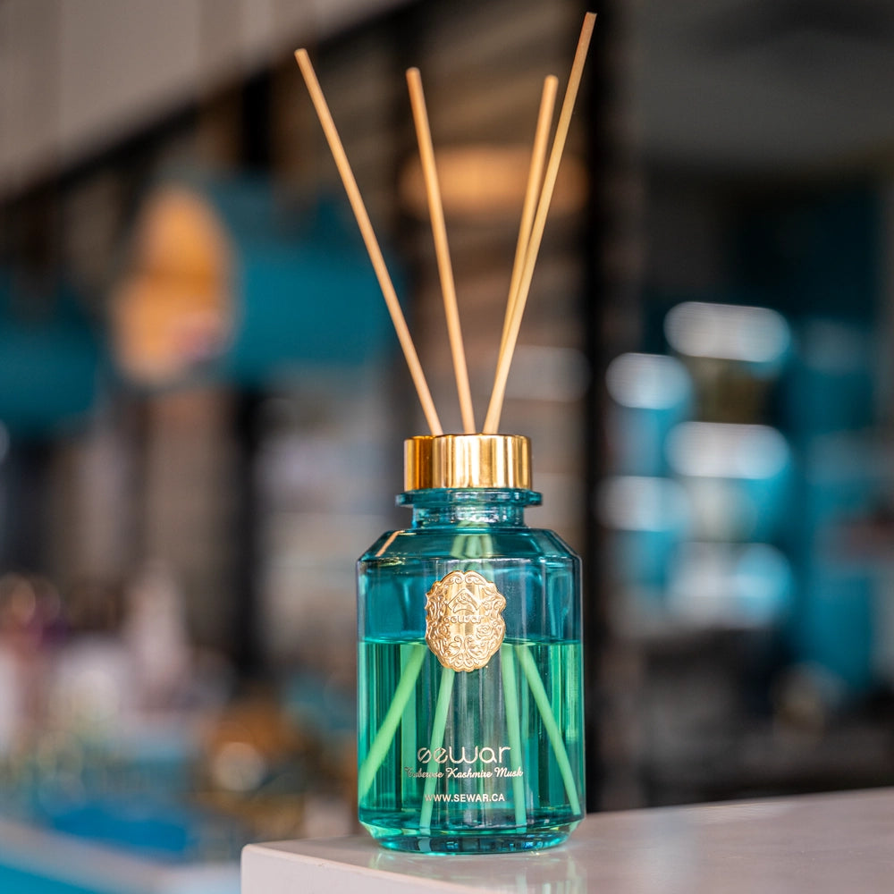 A sleek, premium glass bottle with a metallic logo, filled with Sewar Tuberose & Kashmir Musk Reed Diffuser. The diffuser is adorned with elegant reeds, showcasing the fresh and floral fragrance. The design adds a touch of sophistication and luxury, perfect for enhancing the atmosphere of any spa