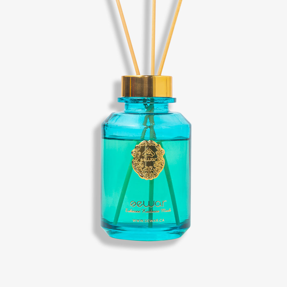 A sleek, premium glass bottle with a metallic logo, filled with Sewar Tuberose & Kashmir Musk Reed Diffuser. The diffuser is adorned with elegant reeds, showcasing the fresh and floral fragrance. The design adds a touch of sophistication and luxury, perfect for enhancing the atmosphere of any spa