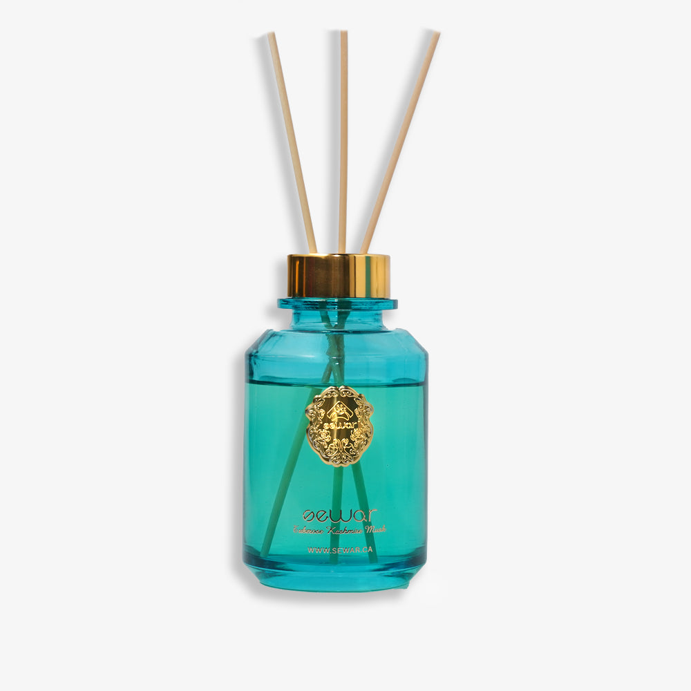 A sleek, premium glass bottle with a metallic logo, filled with Sewar Tuberose & Kashmir Musk Reed Diffuser. The diffuser is adorned with elegant reeds, showcasing the fresh and floral fragrance. The design adds a touch of sophistication and luxury, perfect for enhancing the atmosphere of any spa