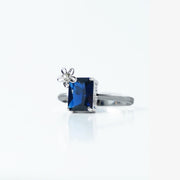 Elegant and unique, this Sterling Silver 925 Blue Sapphire Flower Ring features a stunning rectangular blue stone accented with a delicate flower detail for a feminine touch. Its timeless design makes it a perfect statement piece.