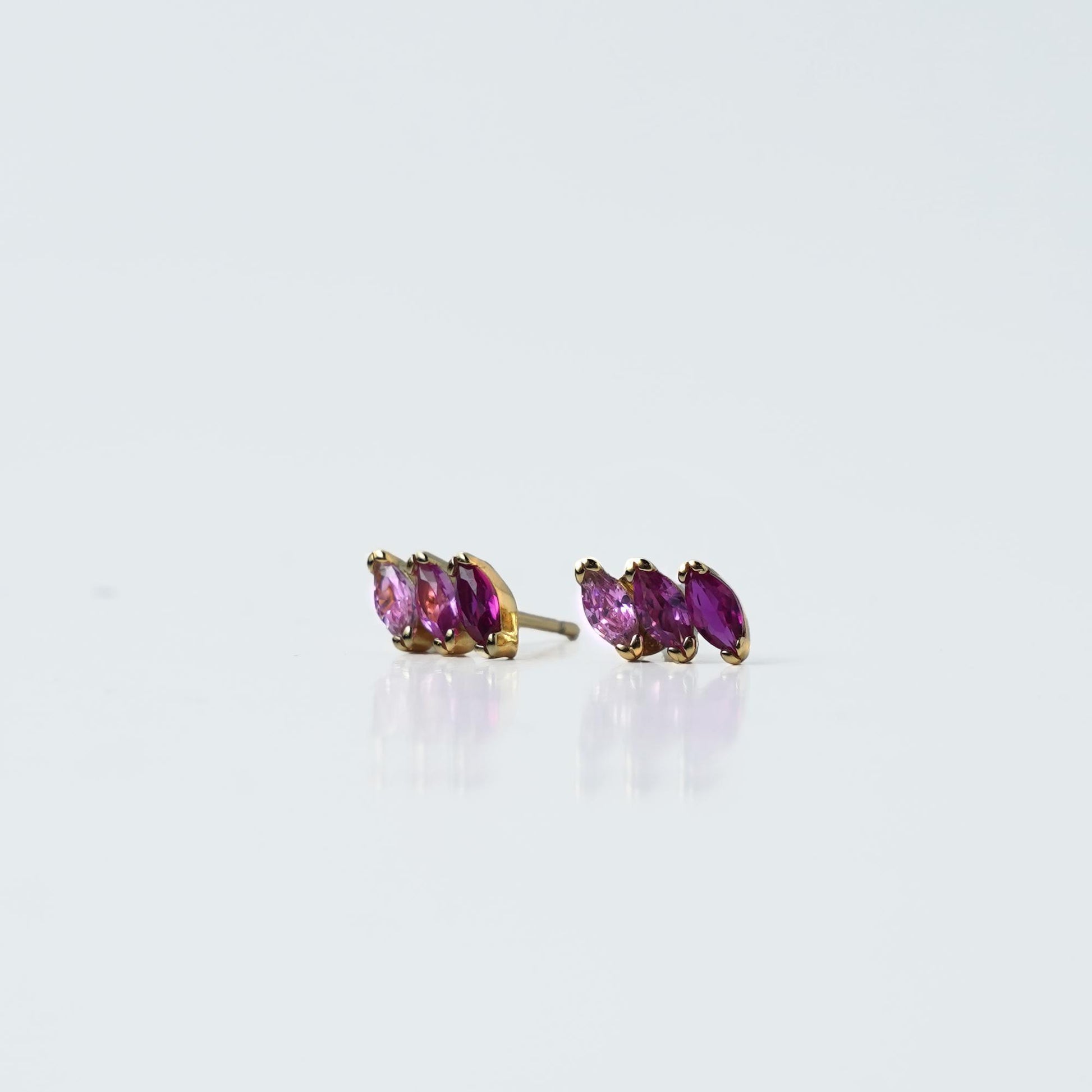 Elegant and stylish, these gold-plated stud earrings feature a row of pink marquise-cut stones, adding a delicate and sophisticated touch to any look.