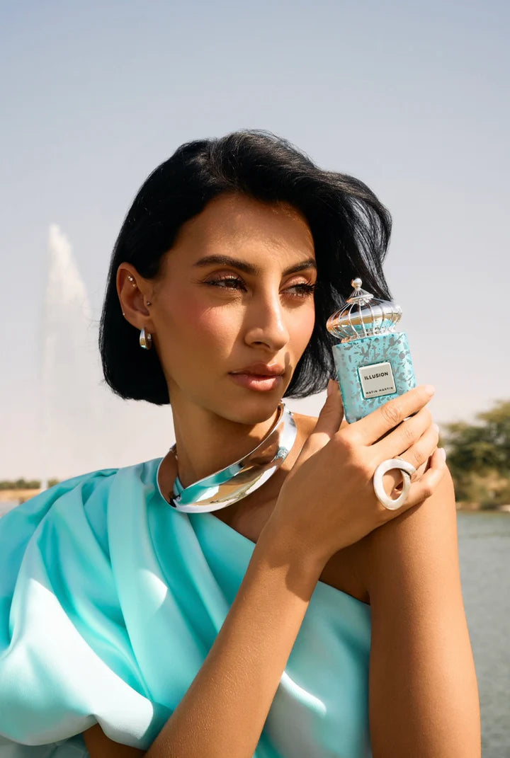 Woman holding a blue and white product with a scenic background. matin martin fragrances buy in canada.  online