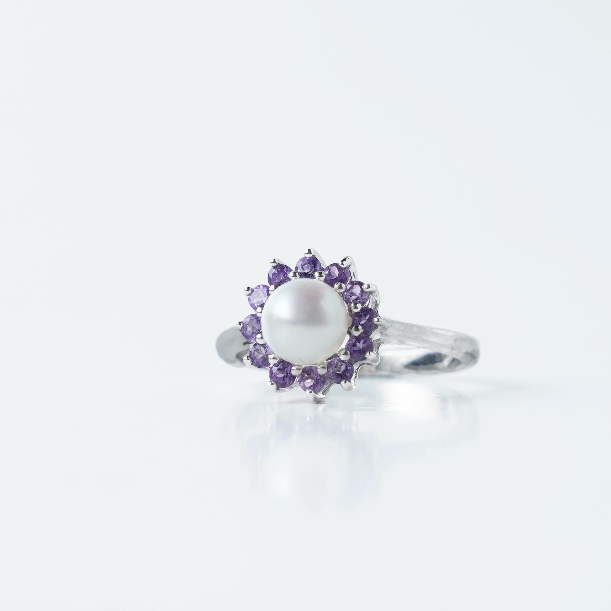 Timeless and elegant, this Sterling Silver 925 Pearl &amp; Amethyst Flower Ring features a beautiful round pearl at the center, surrounded by a halo of sparkling purple stones. Its floral-inspired design adds a touch of sophistication to any look.